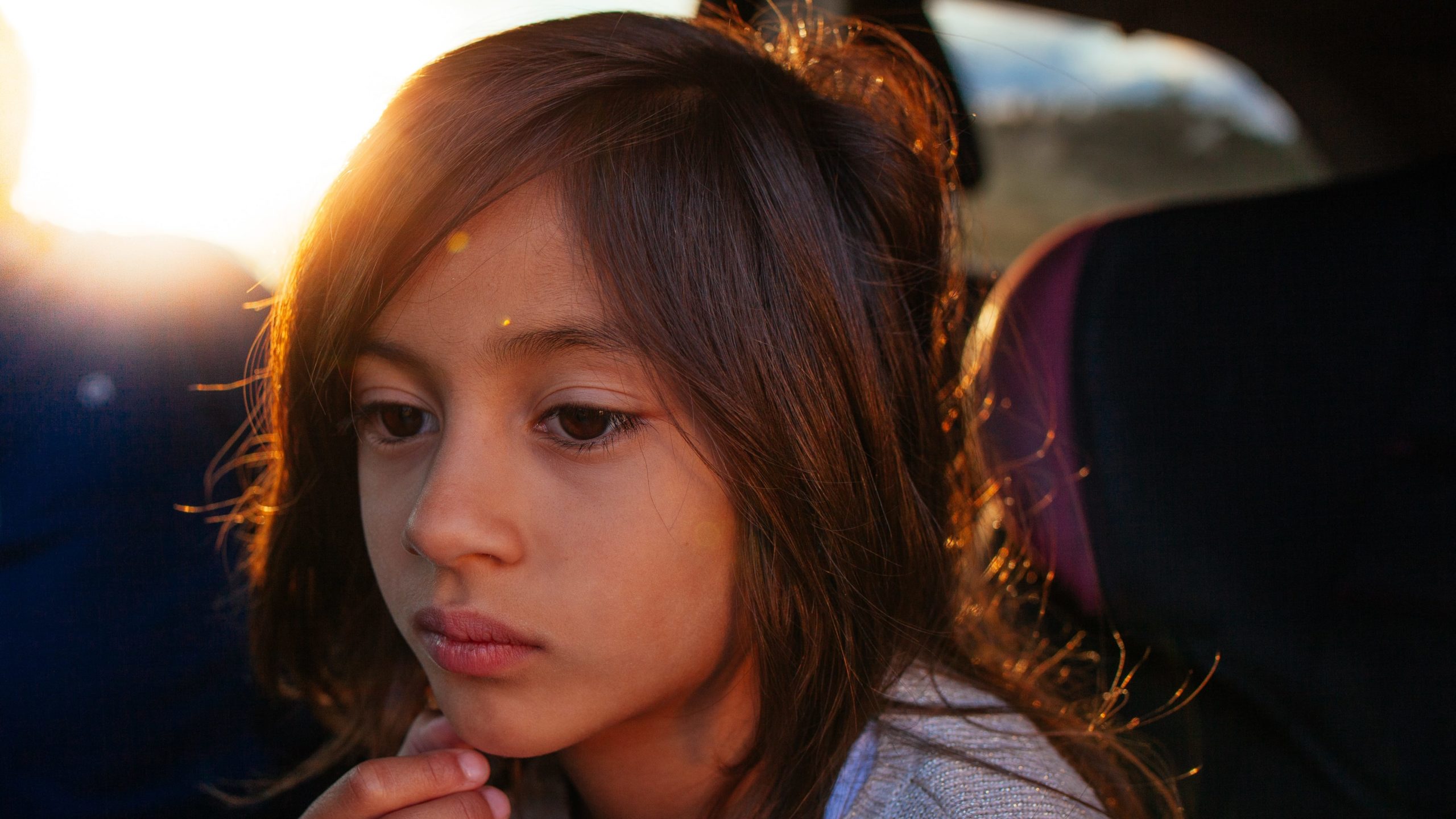 Childhood trauma and addiction go hand in hand. An image of a young girl looking into the distance. 